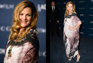 Drew Barrymore in a patterned gown at a LACMA event, smiling with hand on hip.