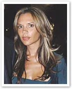 Woman with long hair wearing a dark top, looking directly at the camera.