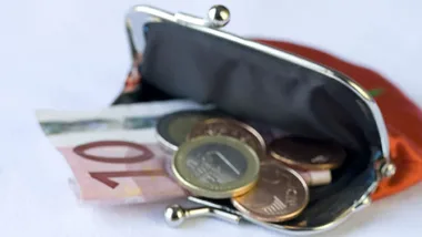 Open coin purse with euro banknote and coins on a white surface.