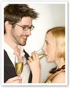 Couple smiling at each other while holding champagne glasses.
