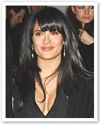 Salma Hayek, wearing a black outfit with long hair, smiles at an event.