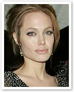 Portrait of a woman with updo hairstyle, earrings, and wearing a black dress.