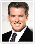 Pierce Brosnan smiling at a formal event, wearing a dark suit and tie.