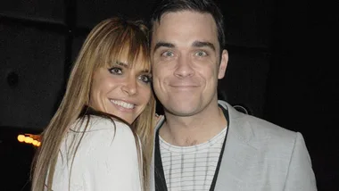 A couple smiling and embracing each other at an event.
