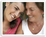 Two women smiling warmly at each other, displaying a close bond.