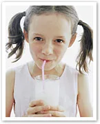 Girl with pigtails drinking milk through a straw.