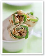 Chicken and vegetable wraps on a plate, with visible spinach and pieces of chicken in a soft tortilla.