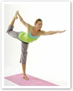 Woman performing a standing yoga pose on a pink mat, balancing on one leg and extending the other behind her.