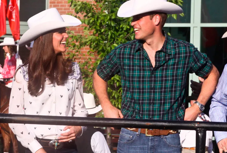 Kate and William wearing cowboy hats, smiling at each other outdoors in Canada.