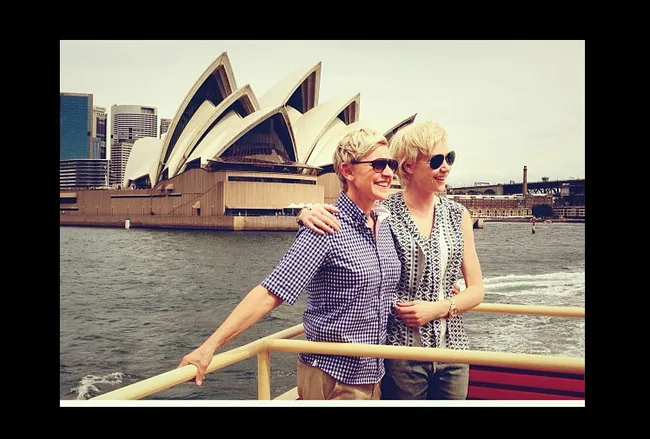 Couple posing happily on a boat with the Sydney Opera House in the background.