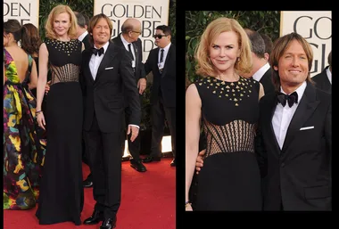 A couple poses elegantly on the Golden Globe red carpet; the woman in a black gown, the man in a classic tuxedo.