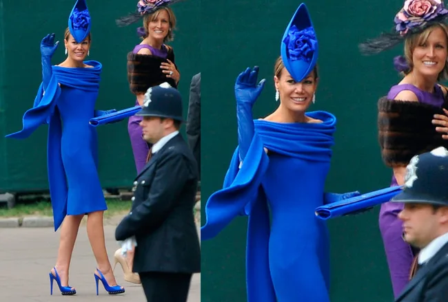 Woman in blue dress and hat waving, with another woman in purple dress in background, surrounded by people.