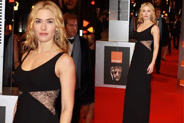 Woman in a black dress with lace details poses on the red carpet at the BAFTAs.