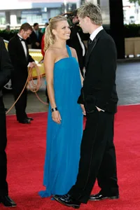 A couple elegantly dressed on the red carpet at the Allan Border Medal event in 2007, engaging in conversation.