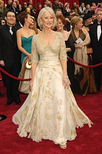A woman in an elegant gown with sequin details poses on the red carpet at the 79th Academy Awards.