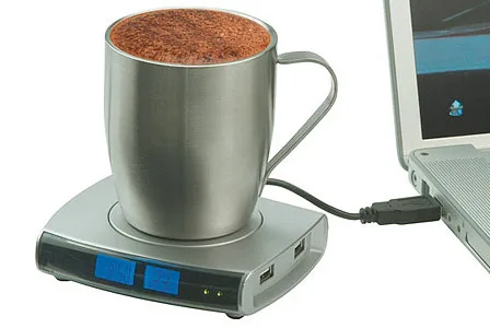 Stainless steel mug on a USB-powered heated coaster, connected to a laptop.