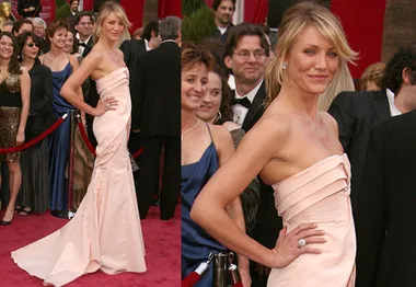 Cameron Diaz in a strapless pink gown on the Oscars red carpet, surrounded by attendees, smiling and posing.