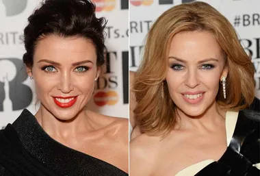 Two women posing on the red carpet at an event, wearing elegant black dresses and styled hair.