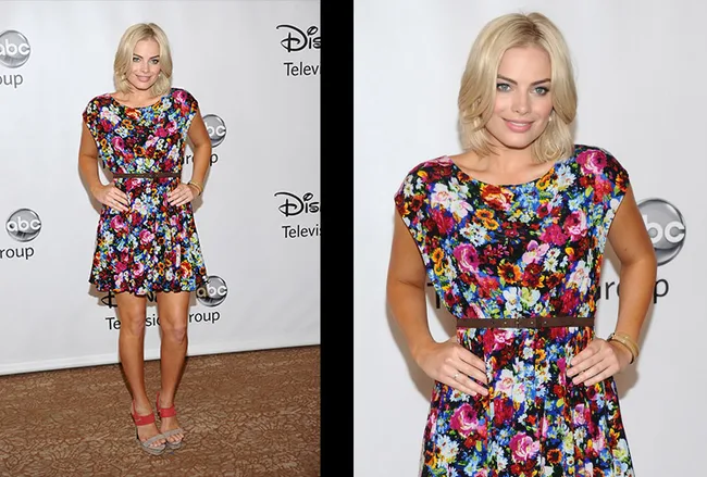 Blonde woman in a colorful floral dress at a Disney ABC Television event, posing with hands on hips.