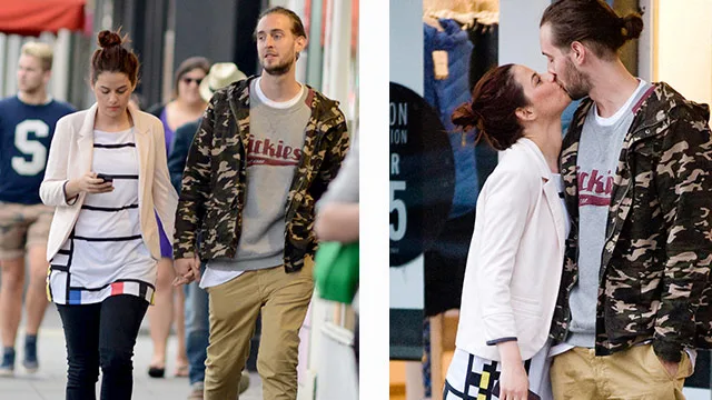 Couple walking hand-in-hand; woman checks phone. Later, they share a kiss in casual outfits on a city street.