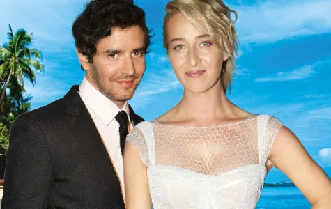 Couple posing in wedding attire on a tropical beach background.