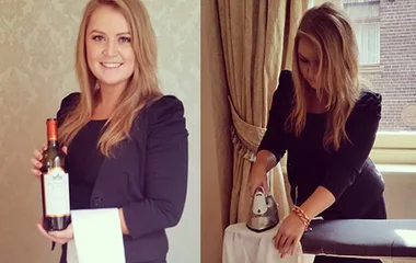 Woman dressed as a butler with a wine bottle and ironing in a luxurious setting.