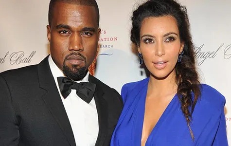 Kim Kardashian and Kanye West at a formal event, posing together in elegant attire.