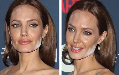 A person with slightly uneven makeup, showing noticeable white powder on the lower face against a red carpet backdrop.