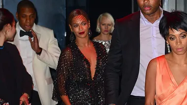 Celebrities leaving an event; one wears a black gown, another in a peach dress, with others in formal attire.