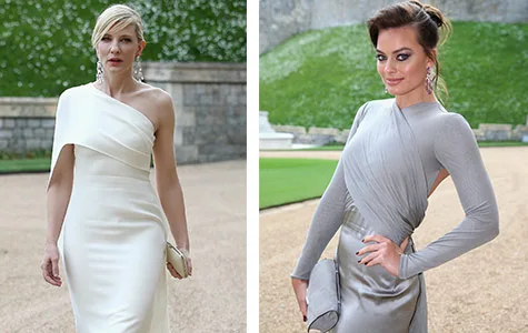 Two women in elegant gowns at an outdoor event; one in white off-shoulder, the other in silver with intricate design.
