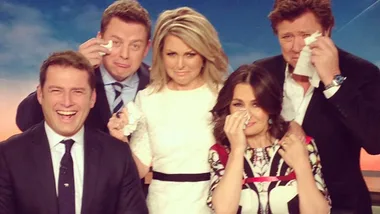 Group photo of five people in a studio setting, with some holding tissues and pretending to cry, while one person smiles.