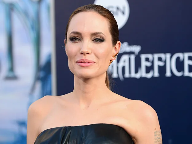 I don't know who this person is, but they are at an event for Disney's "Maleficent" wearing a strapless black outfit.