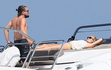 Man and woman relaxing on a yacht under sunny skies.