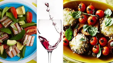 Mixed salad, red wine being poured into a glass, and baked vegetables with cheese and tomatoes on a plate.