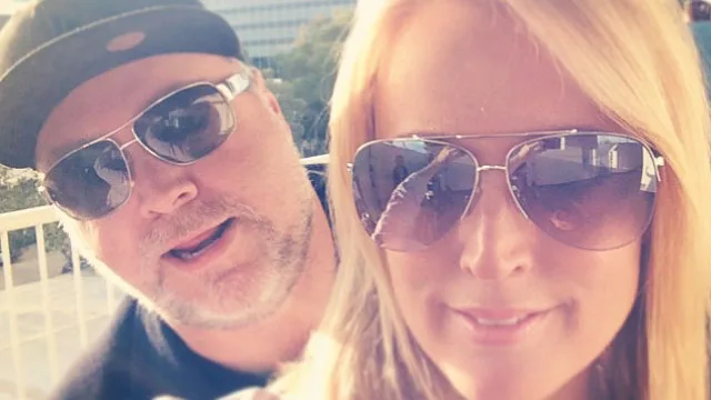 Two people wearing sunglasses outdoors, smiling.