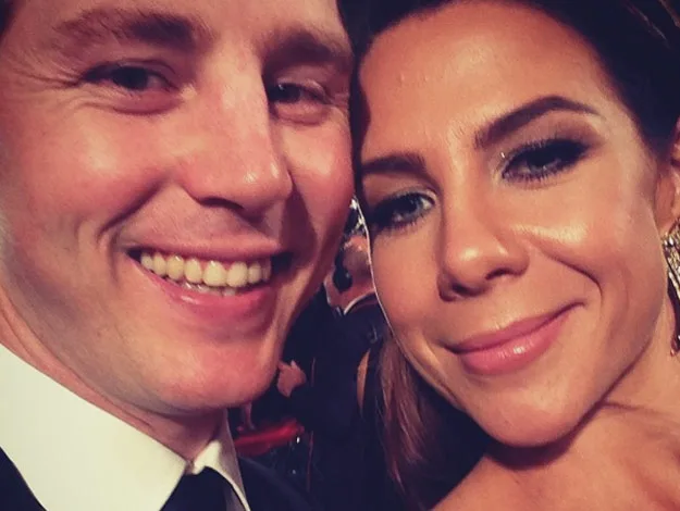 Two people smiling at the camera, dressed in formal attire, possibly at an event.