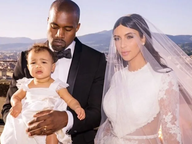 I don't know who these people are, but it shows a man in a tuxedo, a woman in a wedding dress, and a child outdoors.