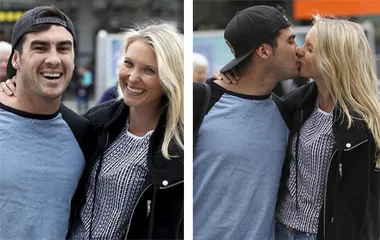 Couple smiling and then kissing outdoors, both in casual clothes.