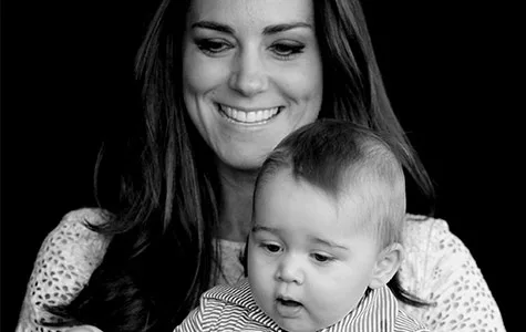 Duchess Catherine holding Prince George, both smiling, in a black and white photo.