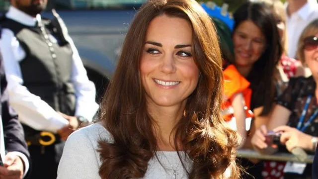 I don't know who this is, but the image shows a smiling woman with brown hair among a crowd outdoors.