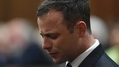 Man in a suit appearing emotional in a courtroom setting.