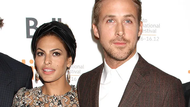 Couple posing at a film festival event, wearing formal attire.