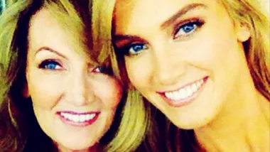 Two smiling women close together, one with long blonde hair.
