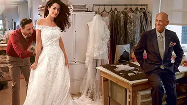 Amal fitting her wedding gown with designer and tailor in a fashion studio setting.