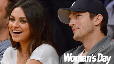 Couple smiling while sitting close at an event; Woman's Day logo in corner.