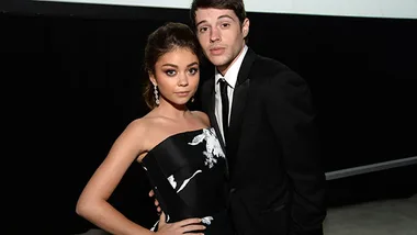 Two individuals dressed formally, posing together at an event.