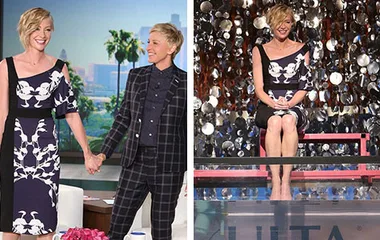 Ellen and Portia holding hands on stage, with Portia sitting above a dunk tank, surrounded by a confetti backdrop.