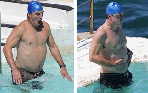 Man wearing a blue swim cap in a pool, splashing water.