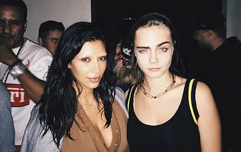 Two women with bleached eyebrows posing together at a social event.