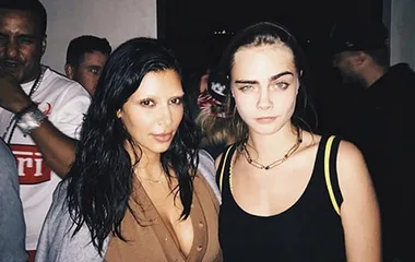 Two women with bleached eyebrows posing together at a social event.